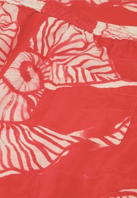 Rode stoffen shorts met een spiraal- en zebrapatroon, voorzien van een elastische tailleband en een zijzak.