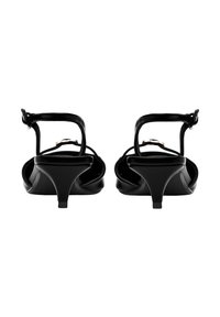 Sandales à talons noires avec une finition brillante, dos ouvert et bride à la cheville. Elles possèdent un talon fin et un design minimaliste. Aucun motif visible.
