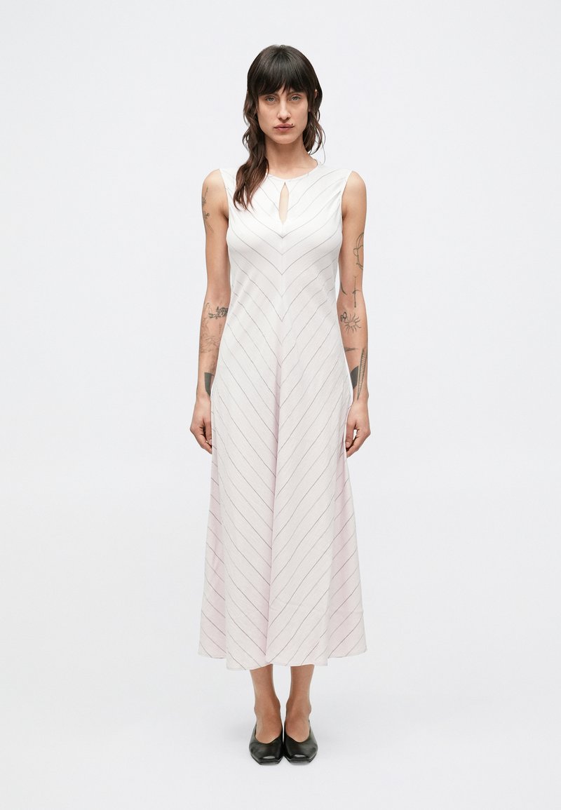 Šaty dĺžky po kolená v svetloružovej farbe s diagonálnymi pruhmi. Majú výstrih s otvorom v tvare kľúčovej dierky a rozšírený áčkový strih. Nosené s čiernymi topánkami.