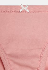 Ružičaste pamučne gaćice s mekim tekstilom, čipkastim rubovima i malim belim mašnicom na pojasu.