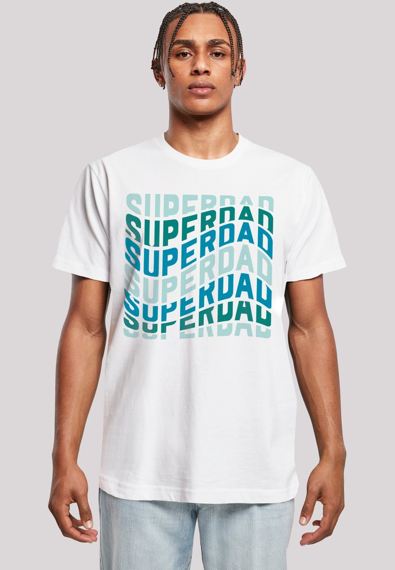 Weißes Baumwoll-T-Shirt mit dem Text "SUPERDAD" in überlappenden blauen und grünen Buchstaben, die in ihrer Opazität und Ausrichtung variieren.