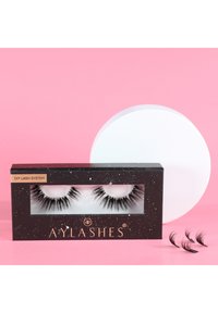 Black synthetic eyelashes in a transparent display box with a shiny black exterior. Includes three additional loose lashes and a round white applicator pad.