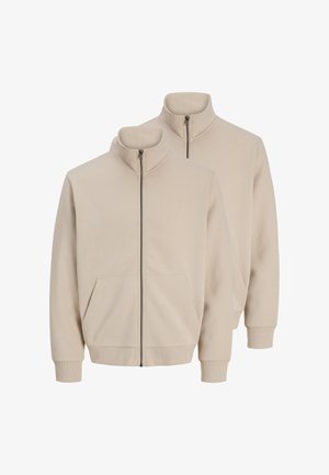 Zwei beige Jacken mit Reißverschluss, Stehkragen, Taschen vorne sowie gerippten Bündchen und Säumen, gezeigt vor weißem Hintergrund.