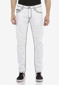 Weiße Jeans aus Denim mit schwarzem Stick, schlanke Passform, fünf Taschen, Frontknopfverschluss und einem Markenetikett am Taillenbund.