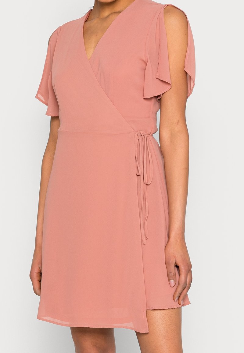 Różowa sukienka kopertowa wykonana z lekkiego materiału. Posiada falbaniaste rękawy, wiązanie w talii oraz dekolt w kształcie litery V.