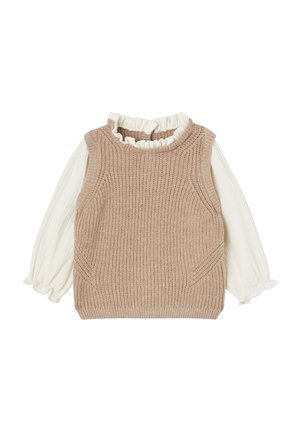 Beżowa, dzianinowa kamizelka bez rękawów, nałożona na białą bluzkę z długim rękawem, z falbanami przy kołnierzyku i mankietach, ułożona płasko na białym tle.