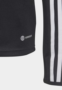 Schwarzes T-Shirt mit strukturiertem Finish. Verfügt über weiße Streifen an den Seiten und ein kleines, weißes "AEROREADY"-Logo nahe dem Saum.