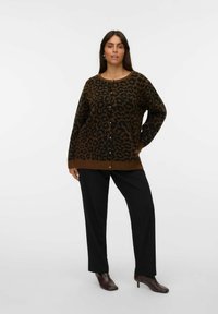 Cardigan en imprimé léopard marron avec un col rond, des boutons sur le devant et des manches longues, associé à un pantalon noir et des bottes à talons marron.