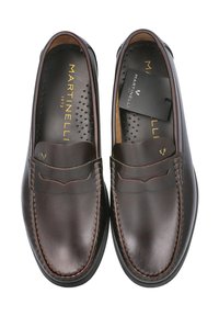 Mocasines de cuero marrón con detalles de costura y un acabado suave. Presentan una plantilla acolchada y una etiqueta extraíble de marca en el interior.