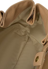 Taanist nahast käekoti sisemus, sileda beeži kangaseestusega. Sisaldab kahte küljetaskut ja turvalist nööpkinnitust.