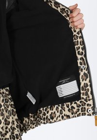 Schwarze Jacke mit einem Innenfutter im Leopardenmuster. Verfügt über einen elastischen Bund, einen Reißverschluss und ein Pflegeetikett. Glatte Textur, modernes Design.