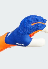 Plave i narančaste rukavice za golmana s teksturiranim zahvatom i bijelim zapešćem. Imaju čvrsto prianjanje od tkanine i marku "Predator" sa strane.