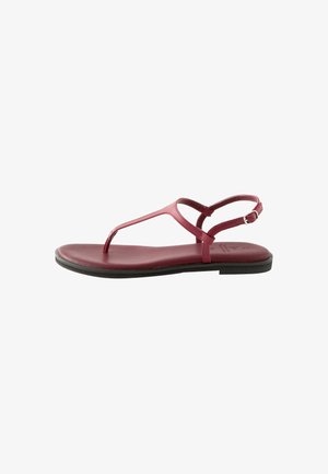 Rote Lederflatsandaletten mit T-Riemen-Design, verstellbarem Knöchelriemen und glatter Sohle. Minimalistischer Stil mit einer Sohle aus schwarzem Gummi.
