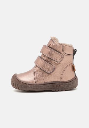 Botte enfant en or rose métallisé avec deux bandes Velcro, doublure en peluche, semelle marron texturée et languette à l’arrière.