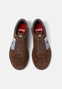 Brown suede sneakers with gray and blue accents, featuring a rounded toe, classic lace-up design, and red insoles displaying "CAMPER."