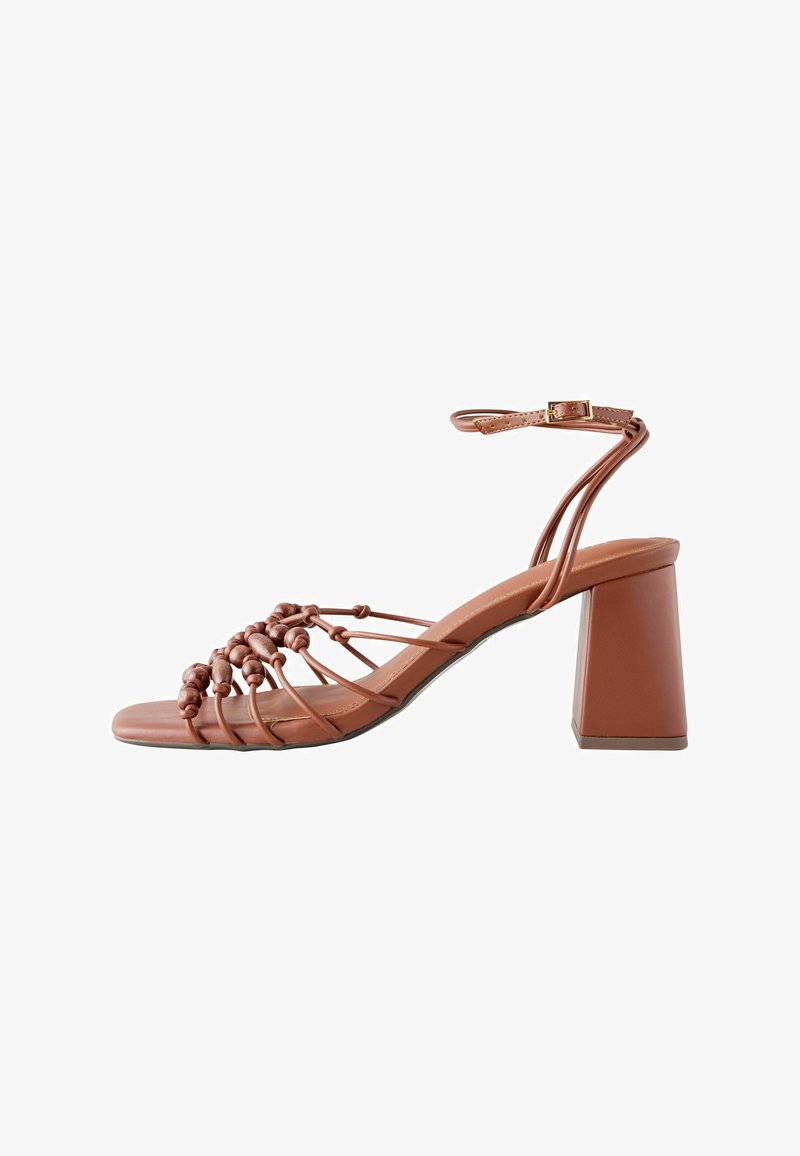 Sandale en cuir marron à bout ouvert avec des brides nouées, une boucle à la cheville et un talon bloc épais.