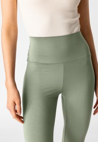 Leggings a vita alta in morbido tessuto verde chiaro strutturato, con un design senza cuciture e una silhouette aderente.