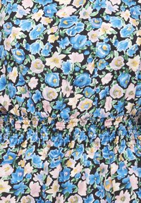 Tissu floral avec des fleurs bleues, roses et jaunes et des feuilles vertes sur un fond noir avec une couture élastique froncée.
