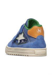 Baskets en textile bleu et en daim avec un détail en étoile, des accents verts et un patch talon marron. Présente une sangle Velcro et une semelle texturée.