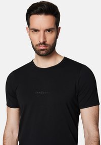 Czarny t-shirt z krótkim rękawem i okrągłym dekoltem, z dyskretnym logo Lancerto w ciemnym nadruku z przodu. Miękki, gładki materiał.