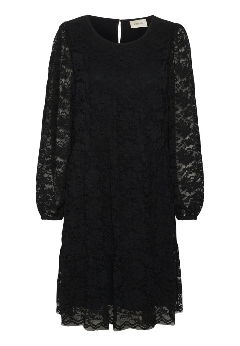 Juoda nėriniuota suknelė su apvaliu kaklu, ilgomis permatomomis rankovėmis ir sluoksniuotu sijonu. Suknelė turi raktelio formos iškirpimą nugaros pusėje.