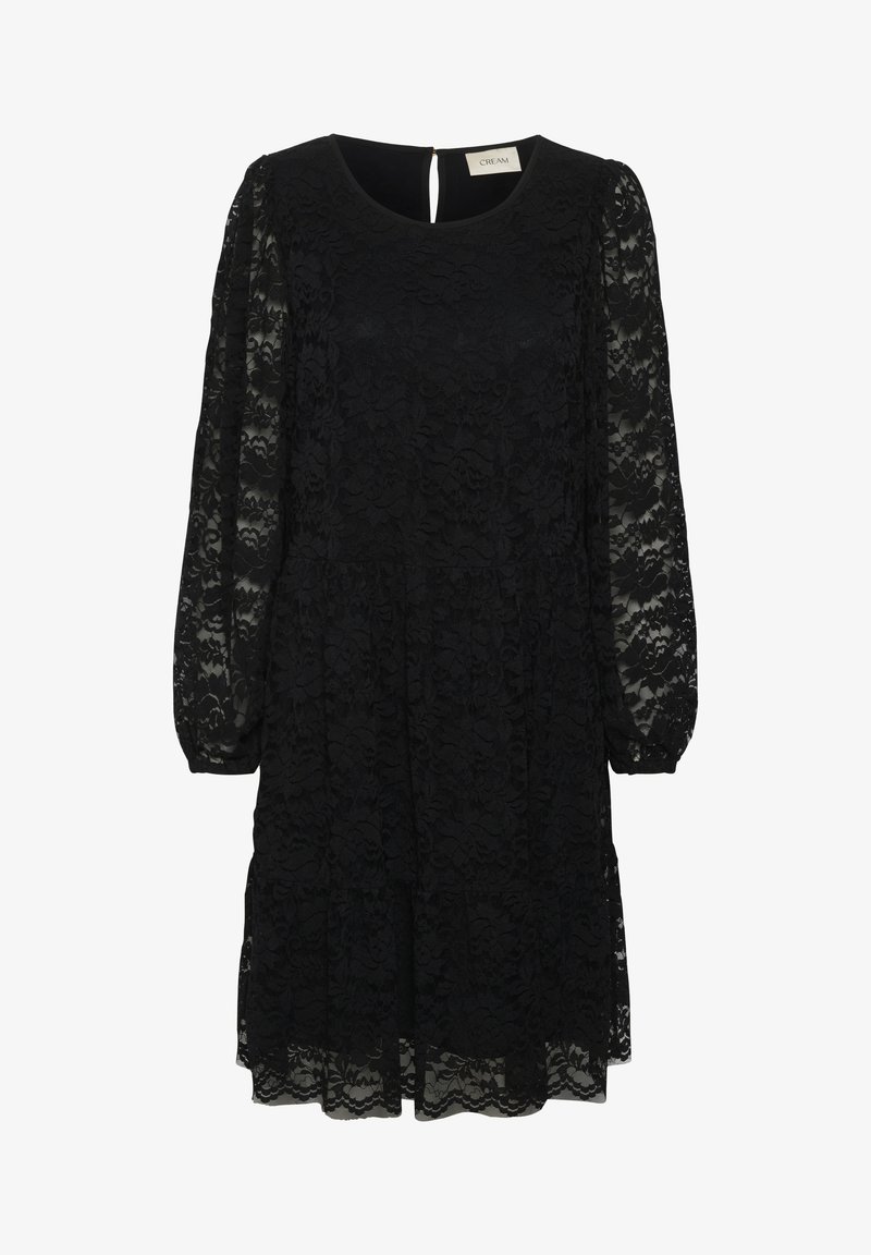 Juoda nėriniuota suknelė su apvaliu kaklu, ilgomis permatomomis rankovėmis ir sluoksniuotu sijonu. Suknelė turi raktelio formos iškirpimą nugaros pusėje.