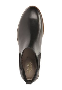 Czarne skórzane botki sięgające kostki z elastycznymi bokami, okrągłym noskiem i kontrastującą brązową gumową podeszwą. Widoczne logo Clarks wewnątrz.