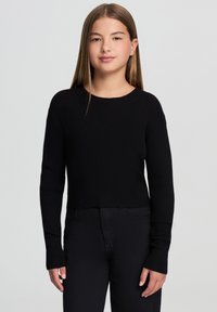 Czarny dziany sweter o kroju cropped z długimi rękawami, ribbową teksturą i okrągłym dekoltem, w połączeniu z czarnymi spodniami. Prosty design, bez wzorów.