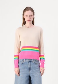 Lys beigefarget genser laget av mykt materiale, med en rosa og flerfarget stripet nederkant og ermer. Utringningen er rund og ribbet.