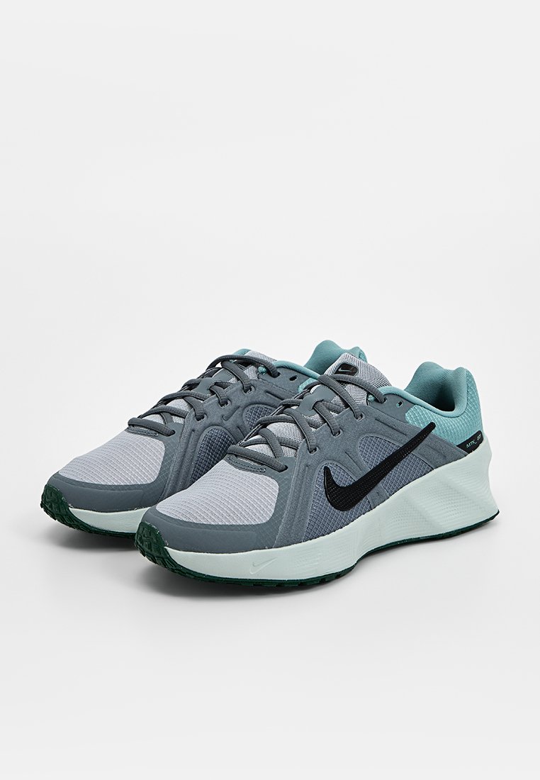 Zapatillas deportivas en gris y azul claro con parte superior de malla y sintética, logo de Nike negro, suela texturizada y cuello acolchado.