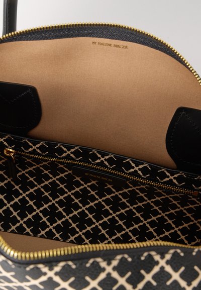 Εσωτερικό τσάντας με μαύρο και μπεζ σχέδιο, με τσέπη με φερμουάρ, χρυσά μεταλλικά στοιχεία και λείο, καφέ φόδρα. Διαθέτει ετικέτα με το όνομα της μάρκας στο εσωτερικό.