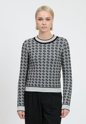 Schwarz-weißer, gemusterter Strickpullover mit Rundhalsausschnitt und langen Ärmeln, der an den Bündchen und am Saum mit einem gepunkteten Abschluss verziert ist.