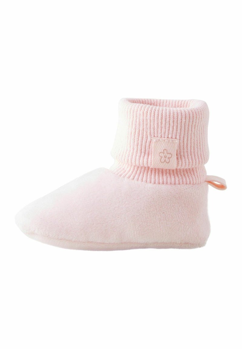 Chausson en polaire rose avec un poignet côtelé et une étiquette décorative. Texture lisse, forme douce et accent en boucle pour un enfilage facile.