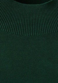 Grüner gestrickter Pulloverwollstoff mit ribbeliger Textur und hohem Kragen. Das Material wirkt weich und hat eine einheitliche Farbe.