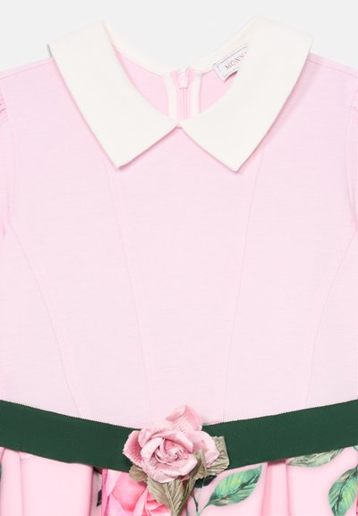 Rosa Kleid mit einem weißen, runden Kragen und einem grünen Bandgürtel. Verfügt über ein florales Design mit rosa Rosen und grünen Blättern auf dem Rock.