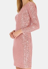 Różowa sukienka z cekinami, z długimi rękawami i dopasowanym krojem. Posiada teksturowany materiał oraz dekolt w kształcie litery V, co nadaje jej elegancki wygląd.