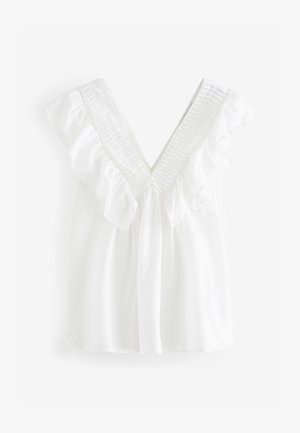 Valkoinen puuvillatoppi, jossa on V-kaula-aukko ja röyhelöhihat. Sisältää smokkikuvion kaula-aukolla ja pehmeän, sileän tekstuurin.