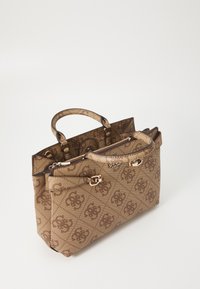 Vaaleanruskea käsilaukku, jossa on teksturoitu kangas ja toistuva logokuviointi. Mukana kaksi yläkahvaa ja kullanväriset korostukset.