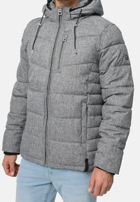 Graue Steppjacke mit Kapuze, vorne mit Reißverschluss, gesteppten Nähten und verstellbaren Kordelzügen. Das Material hat eine strukturierte Oberfläche.