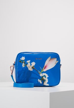 Niebieska torebka z kwiatowym wzorem o błyszczącym wykończeniu, z różowym motywem magnolii, złotymi okuciami i odpinanym paskiem.