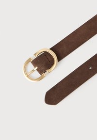 Brązowy pasek zamszowy z dużą złocistą metalową klamrą; płaski pasek o gładkiej fakturze i zaokrąglonym końcu, posiadający pojedynczy otwór do regulacji.