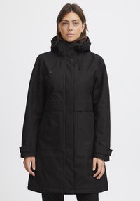 Manteau imperméable noir avec capuche, équipé d'une fermeture éclair centrale et de boutons-pression, deux poches avant et des poignets ajustables. Coupe classique.