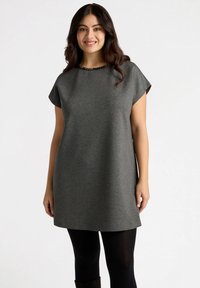 Graues Kurzarm-Tunika-Kleid mit rundem Ausschnitt, das mit einer Perlenakzentuierung versehen ist, locker geschnitten und aus glattem Stoff gefertigt. Wird über schwarzen Leggings getragen.