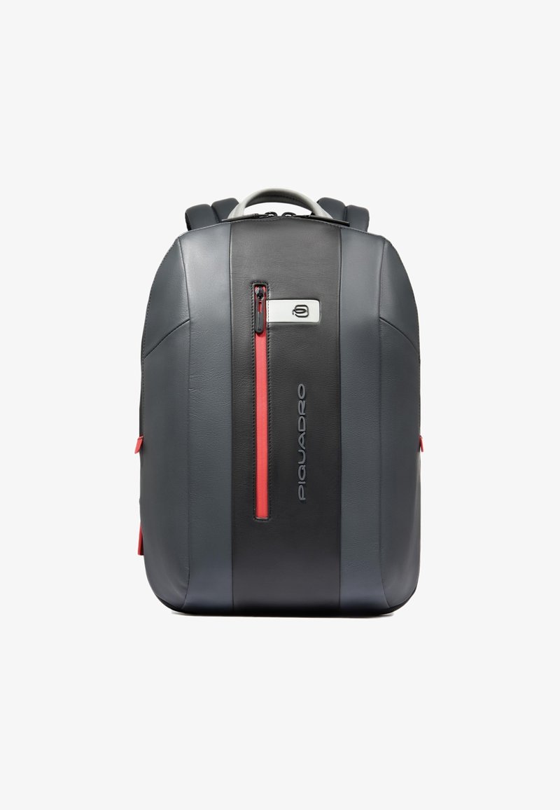 Sac à dos en cuir gris avec des accents de fermeture éclair rouges, une poche avant et des bretelles réglables. Présente une texture lisse et un design moderne.