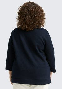 Navyfarbener strukturierter Pullover mit Dreiviertelärmeln, abgerundetem Ausschnitt und lässigem Schnitt. Schlichtes, modernes Design.