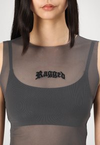 Haut gris transparent en tissu en maille avec un col en scoop et le logo "Ragged" brodé en noir sur la poitrine.