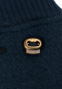 Mornarstvo plava vuna s rebrastim pletenim vrhom, koji sadrži metalni detalj u boji mesinga i crnu nit provučenu kroz njega.