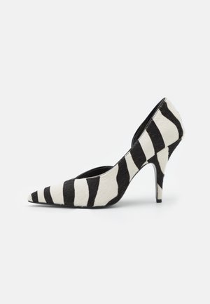 Chaussure à talon haut à bout pointu avec des rayures zébrées noires et blanches et un talon aiguille fin.