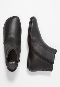 Black leather ankle boots with side zipper, textured surface, rounded square toe, shown from top and side views on white background.