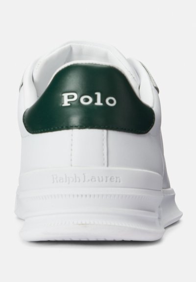 Baltie sporta apavi ar zaļo ādas papēdi, iegravētu "Polo" logotipu un teksturētu baltu gumijas zoli. Ievērojams ar minimālistisku dizainu un tīrām līnijām.